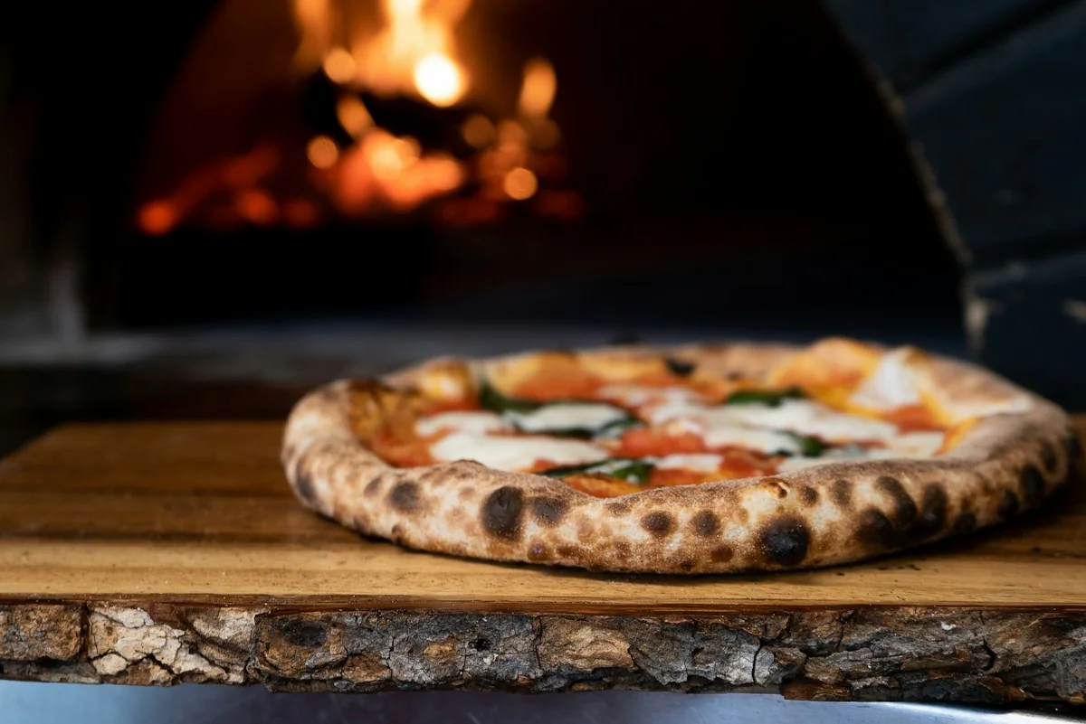 Pizza beside a wood-fired oven