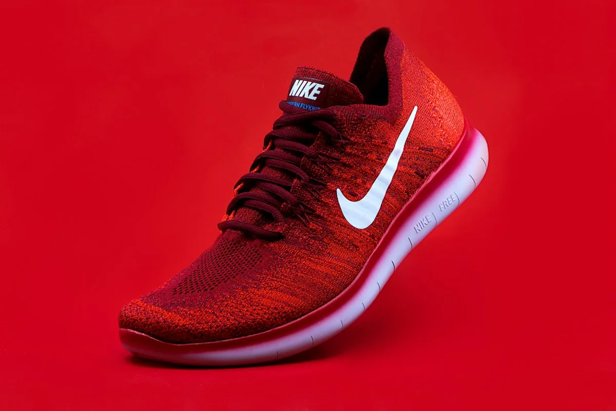 A red athletic shoe photographed against a red background